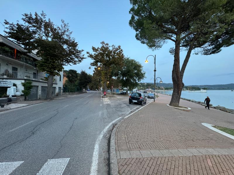 Die Einfahrt zum Parkplatz der Via Eduardo Acton vom Seeufer in Passignano sul Trasimeno